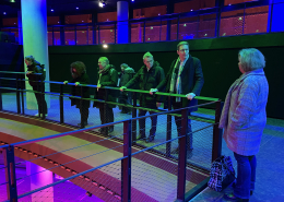 Der Besuch aus Amstelveen steht zusammen mit den Gästen aus dem Bezirk auf einer Empore im Gasometer. Von dort haben sie einen guten Blick auf die untere Bühne im größten Veranstaltungssaal des Gasometers, der für sie in bunten Farben angestrahlt wird.