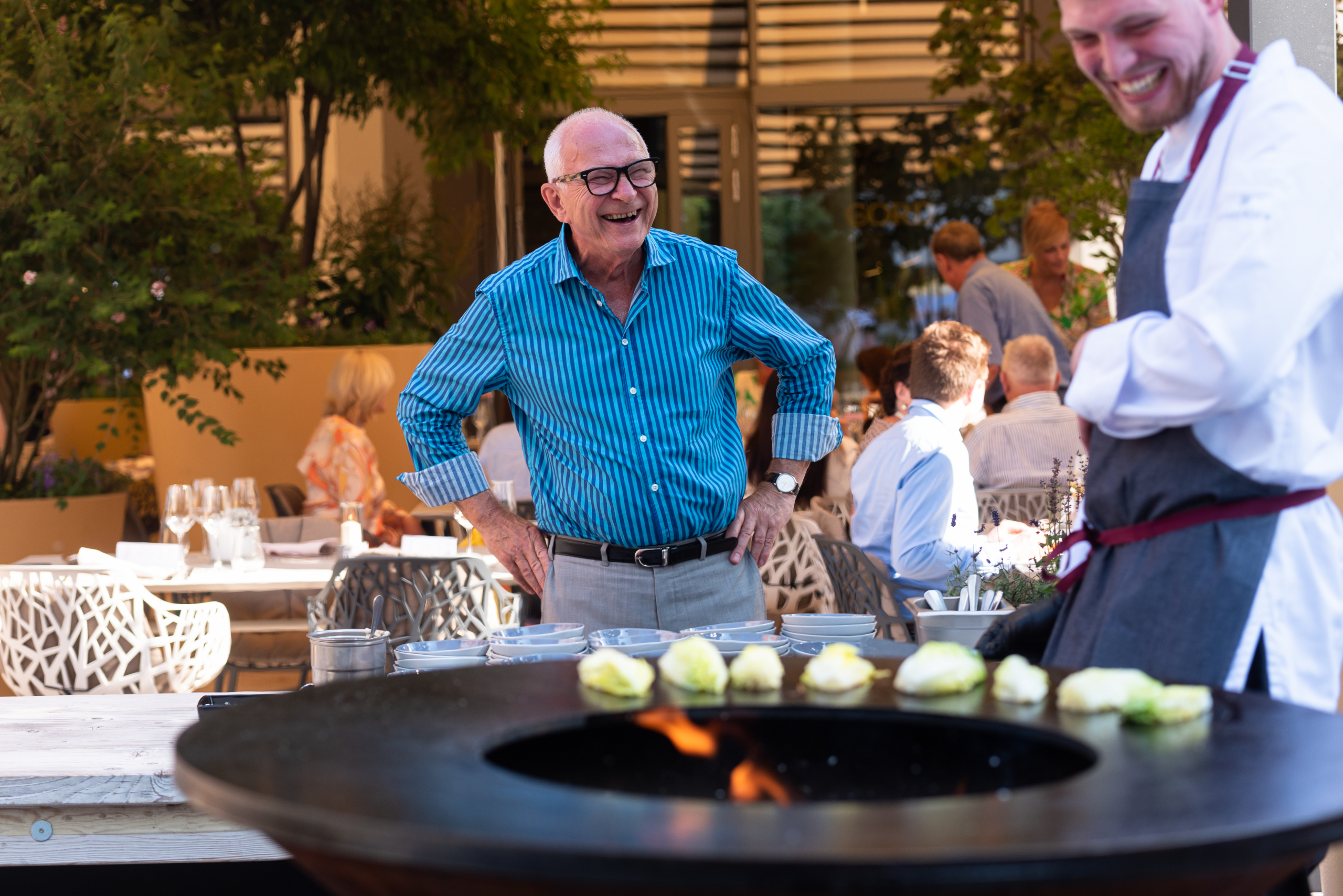 Ein Gast beim Event im the CORD, draußen an einem Grill, die Stimmung ist ausgelassen