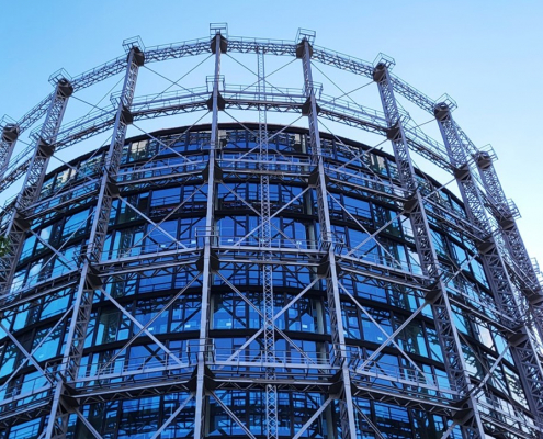 Der Gasometer in Schöneberg mit einem Gerüst aus vielen senkrechten und waagerechten Stahlträgern, die sich gitterartig kreuzen.