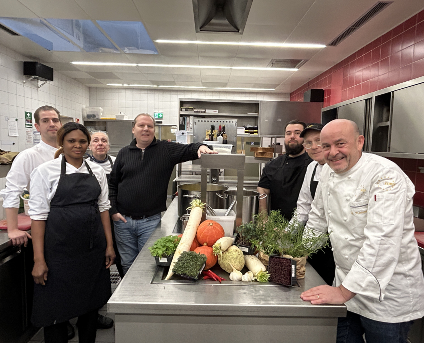 Das Gastro-Team zusammen mit dem Gastronomischen Leiter Thomas Kammeier und dem KUBUS-Mitarbeiter Gernot Zessin vereint in der Küche auf dem EUREF-Campus Berlin.