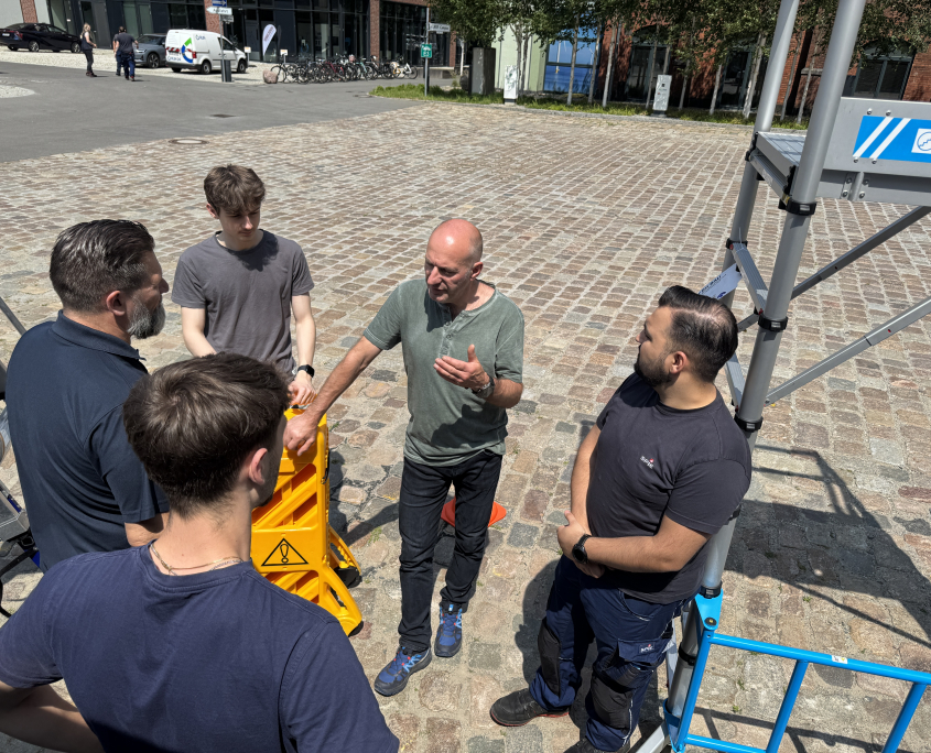 Mitarbeitende von SPIE unterhalten sich bei der Ausstellung zum Thema Arbeitsschutz auf dem EUREF-Campus
