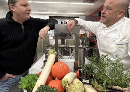 Gernot Zessin von KUBUS und Thomas Kammeier, der Gastronomische Leiter auf dem EUREF-Campus, zusammen in der Küche vor einem Gemüse-Berg, bereit zum Kochen der Suppe.