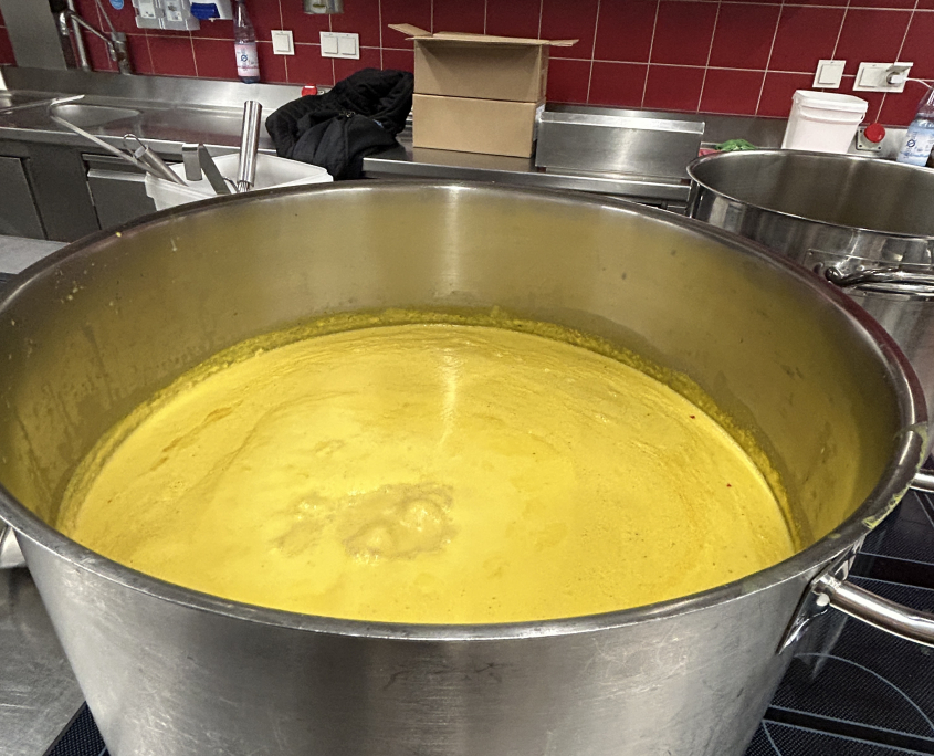 Ein großer Topf mit Suppe, der für den Suppenbus von KUBUS bereit steht.