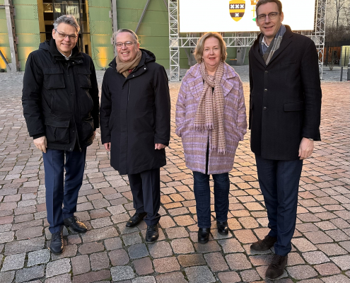 Jörn Oltmann, Stefan Böltes, Karin Teichmann, Tjapko Poppens (v.l.n.r.) stehen auf dem EUREF-Campus vor dem Gasometer für ein Gruppenbild bereit.