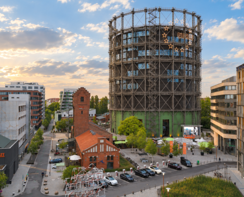 Aufnahme des EUREF-Campus. Man sieht den Gasometer und den Wasserturm bei Sonnenschein.